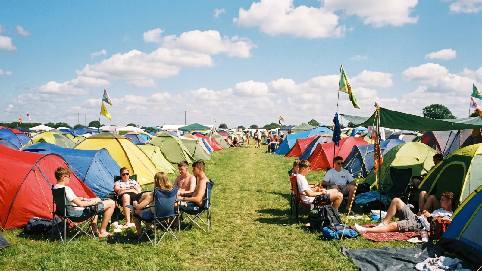 Camping de festival avec des tentes colorées dans un champ ensoleillé